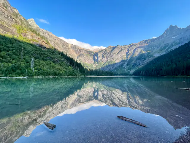 A turquoise mountain lake mirrors a rugged basin on a clear day