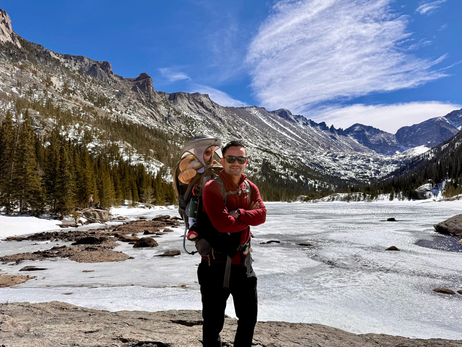 Nitesh and a child on a snowy mountain hike beside a frozen lake
