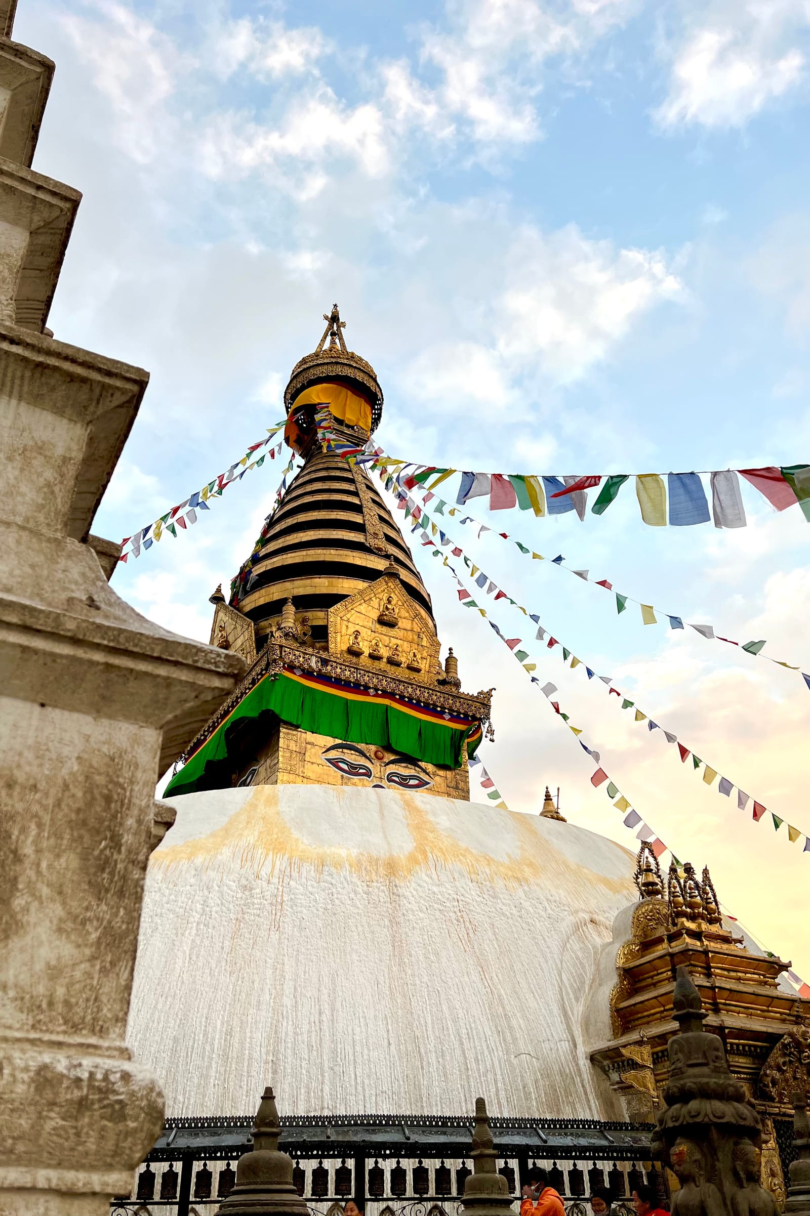 A golden Buddhist stupa in Nepal beneath lines of prayer flags